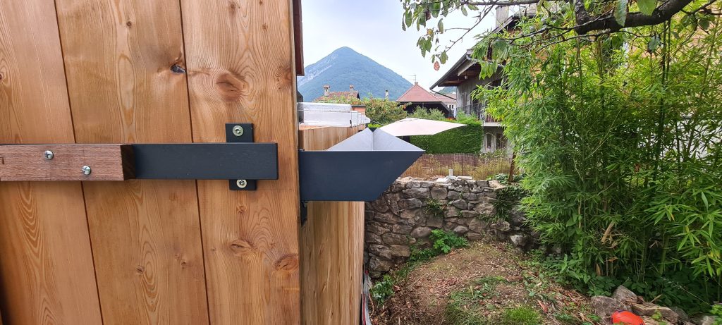 Cette structure mixte bois-métal, fabriquée sur mesure à Menthon-Saint-Bernard, en Haute-Savoie, reflète un parfait équilibre entre robustesse et esthétique. Son design contemporain et ses finitions soignées en bois et métal en font une solution idéale pour des aménagements extérieurs uniques et fonctionnels. Réalisée dans le respect des savoir-faire artisanaux locaux, elle met en avant la qualité des assemblages bois-métal et s’intègre harmonieusement à son environnement naturel. Parfaite pour des projets personnalisés alliant durabilité et design.